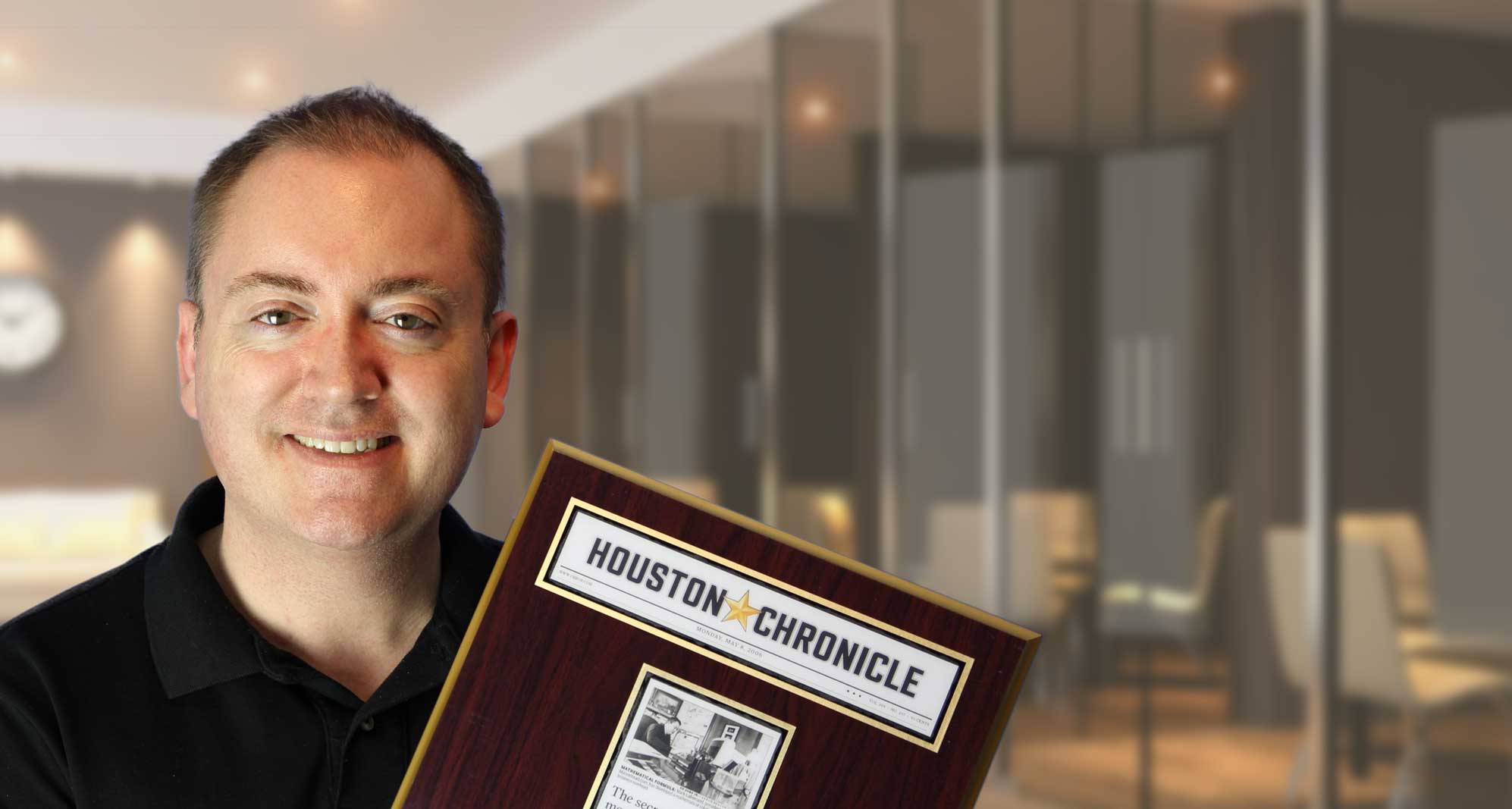 Mark, founder of Astra Estimating, holding the framed Houston Chronicle plaque